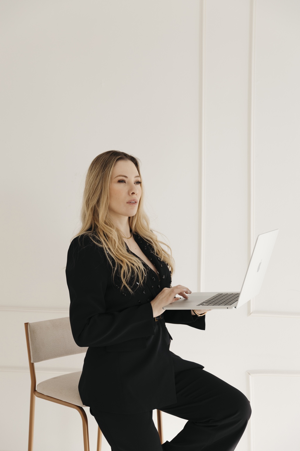 Dra. Daiane Schvendtner sentada, segurando um notebook